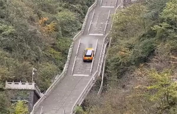 尴尬！一电动车挑战爬天门山台阶失败：溜车后撞坏护栏