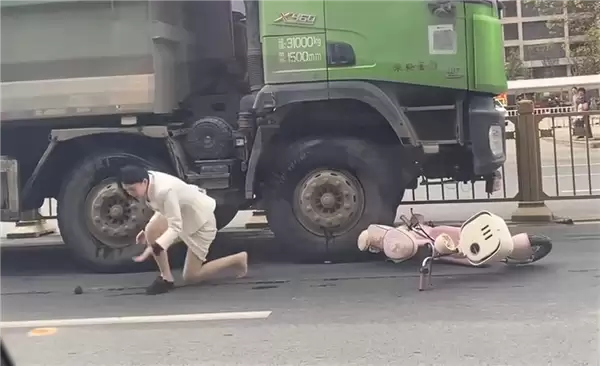 “死亡弯月”盲区太可怕！渣土车撞倒电动车 幸运女子从车底爬出